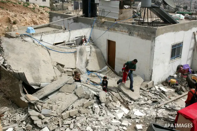 Palestinians stand on the rubble of their house after it was demolished by Israeli army in the Arab Jerusalem neighborhood of Sour Baher on March 19, 2011. Photo by Mahfouz Abu Turk
