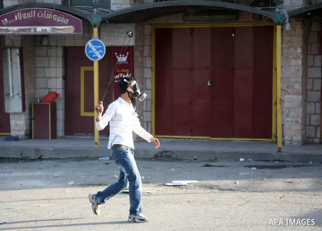 A Palestinian demonstrator throws stones at Israeli soldiers during clashes in the Shufat refugee camp in Jerusalem on March 19, 2011. Hundreds of Palestinians clashed with security forces in east Jerusalem on as tension...
