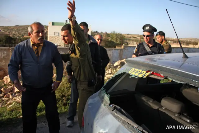 A Palestinian man gestures near his damaged car after Jewish settlers from the Kharsina settlement threw stones at Palestinian drivers on March 21,2011 near Hebron in the Israeli-occupied West Bank, as three Palestinians...