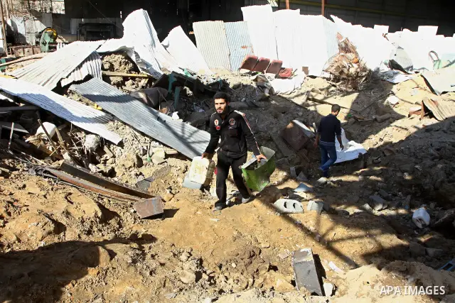 Palestinians inspect a destroyed Hamas compound after an Israeli strike overnight in Gaza City on March 22, 2011 as Israel staged air raids in Gaza overnight, wounding 17 people, Palestinian medics said, after militants...