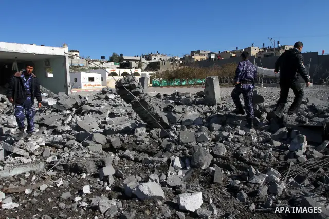 Palestinian Hamas security stand amidst the rubble of a destroyed Hamas compound after its strike by an Israeli war plane overnight in Beit Lahiya town in the northern Gaza Strip on, 22 March 2011. on Feb. 27,2011. Photo...