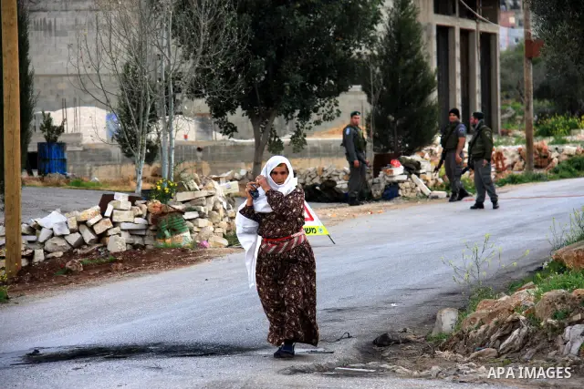 Israeli soldiers prevent Palestinian woman from entering the Awarta during a military operation searching for suspects in the West Bank village of Awarta near Nablus,the army Imposed a curfew in the village in following...