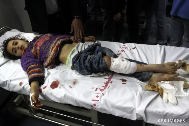 Palestinian medics stand next to a Palestinian injured in an Israeli shells, after was brought to the Shifa hospital in Gaza City, Tuesday, March 22, 2011. Israeli tank fire struck a house in the Gaza Strip on Tuesday, k...