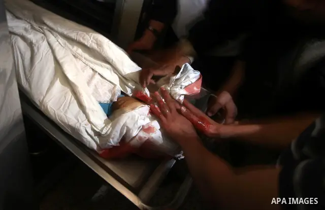 Palestinians mourn next to the body of a Palestinian killed in an Israeli shells, after was brought to the morgue of Shifa hospital in Gaza City, Tuesday, March 22, 2011. Israeli tank fire struck a house in the Gaza Stri...