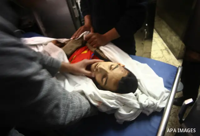 Palestinians mourn next to the body of a Palestinian killed in an Israeli shells, after was brought to the morgue of Shifa hospital in Gaza City, Tuesday, March 22, 2011. Israeli tank fire struck a house in the Gaza Stri...