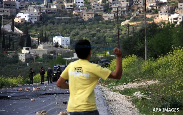 Palestinian youths throw stones at Israeli border police during clashes outside the West Bank Palestinian village of Awarta near Nablus March 22, 2011. Israeli troops have been operating in the area since the fatal stabb...