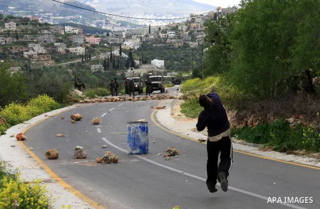 Palestinian youths throw stones at Israeli border police during clashes outside the West Bank Palestinian village of Awarta near Nablus March 22, 2011. Israeli troops have been operating in the area since the fatal stabb...