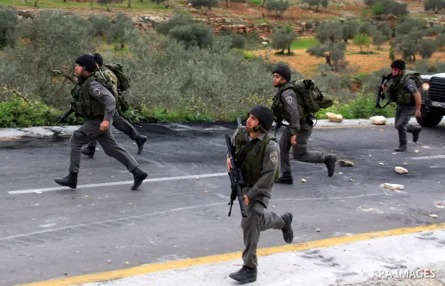 Israeli border policemen run towards Palestinian stone-throwers during clashes outside the West Bank Palestinian village of Awarta, near Nablus March 22, 2011. Israeli troops have been operating in the area since the fat...