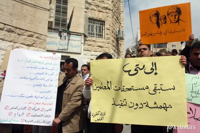 Palestinian teachers take part in a demonstration outside the office of the Directorate of Education in the West Bank city of Hebron on March 23 ,2011. Photo by Najeh Hashlamoun.