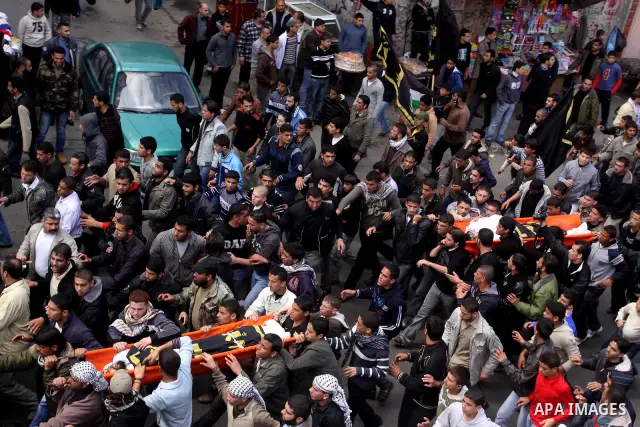 Palestinian mourners carry the bodies of Palestinians during a funeral in Al-Shjaea eastern Gaza City, Gaza Strip, 23 March, 2011 a day after eight Gazans were killed, among them two minors and four militants, as tension...