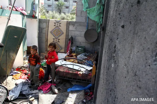 Palestinians survey the scene after Israeli tank fire struck a home in Gaza City March 23, 2011. Israeli air strikes and shelling killed nine Palestinians in the Gaza Strip on Tuesday, medical officials said, in the dead...