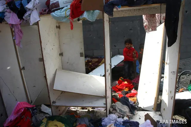 Palestinians survey the scene after Israeli tank fire struck a home in Gaza City March 23, 2011. Israeli air strikes and shelling killed nine Palestinians in the Gaza Strip on Tuesday, medical officials said, in the dead...