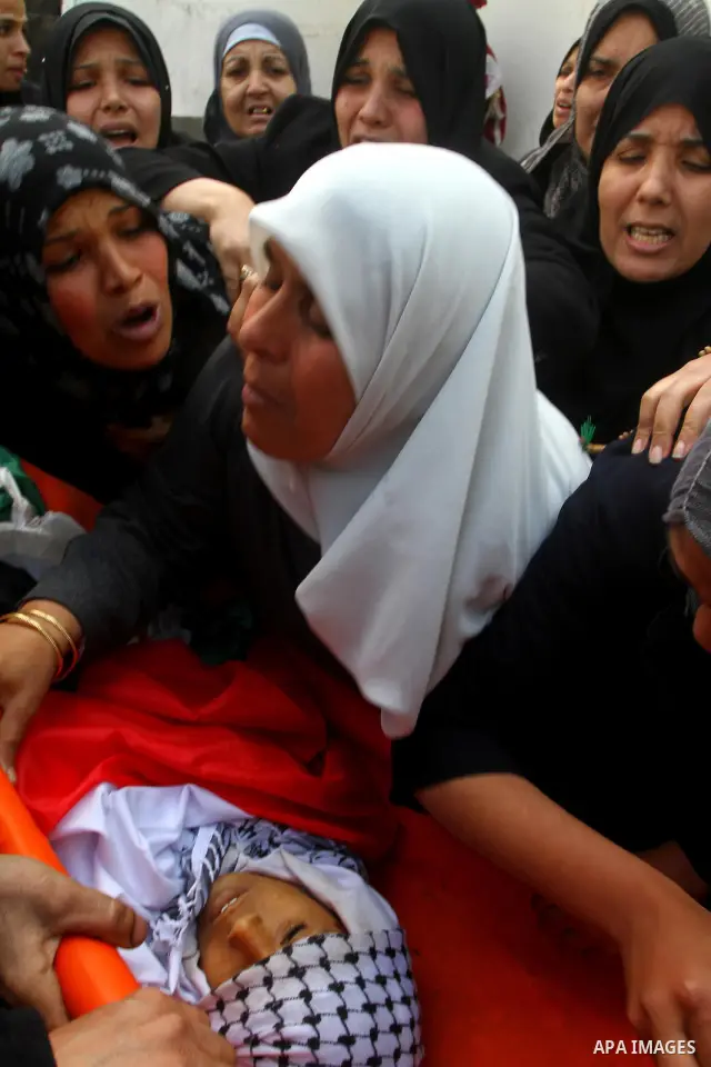 Palestinian women mourn at the bodies of Palestinians during their funeral in Gaza City, Gaza Strip, 23 March, 2011 a day after eight Gazans were killed, among them two minors and four militants, as tensions soared on th...