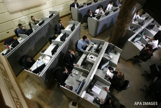 Egyptians work at trading room of the Egyptian stock market in Cairo, Egypt, 23 March 2011. Egypt's benchmark EGX 30 index fell by around 8.9 per cent on 23 March 2011, on the bourse's first day of trading since January...