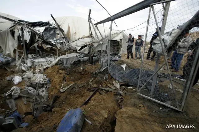 Palestinians survey the damage after an Israeli air strike on a smuggling tunnel in the southern Gaza Strip, along the Gaza-Egypt border March 24, 2011. Israeli aircraft struck targets in the Gaza Strip on Thursday, a da...