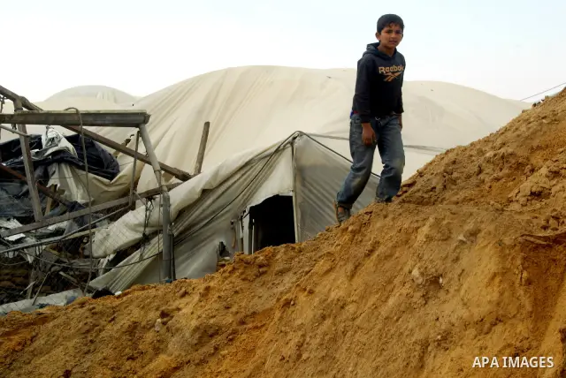 Palestinian boy surveys the damage after an Israeli air strike on a smuggling tunnel in the southern Gaza Strip, along the Gaza-Egypt border March 24, 2011. Israeli aircraft struck targets in the Gaza Strip on Thursday,...