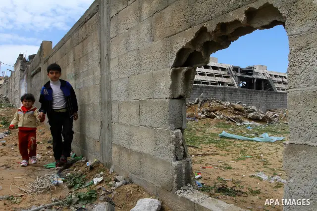 Palestinians walk past the destroyed security office in Gaza City, on March 25, 2011, as Israeli aircraft attacked four targets in the Gaza Strip during the night, lightly wounding three people, in response to Palestinia...