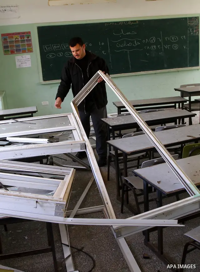 Palestinian man inspects the damage at a school near the destroyed security office in Gaza City, on March 25, 2011, as Israeli aircraft attacked four targets in the Gaza Strip during the night, lightly wounding three peo...
