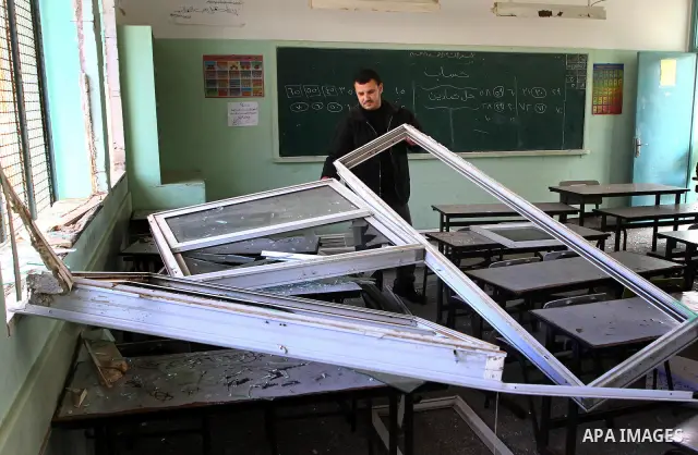 Palestinian man inspects the damage at a school near the destroyed security office in Gaza City, on March 25, 2011, as Israeli aircraft attacked four targets in the Gaza Strip during the night, lightly wounding three peo...
