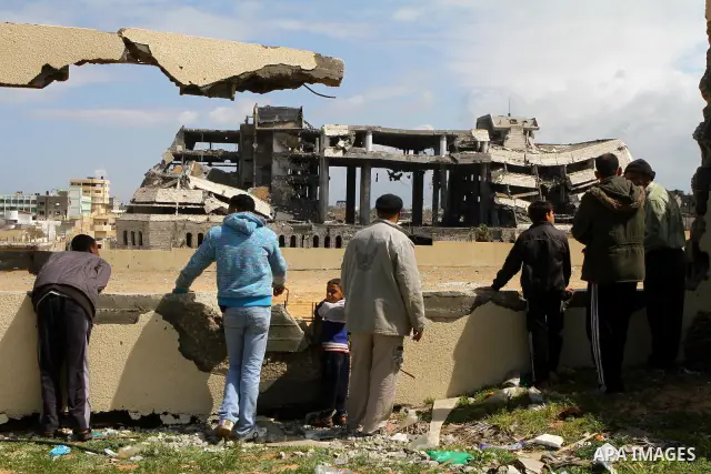 Palestinians observe the destroyed security office in Gaza City, on March 25, 2011, as Israeli aircraft attacked four targets in the Gaza Strip during the night, lightly wounding three people, in response to Palestinian...