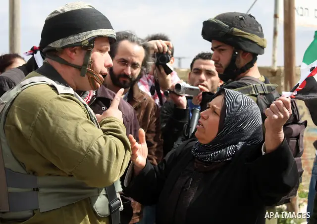 Protesters argue with an Israeli soldier during a demonstration against Israel's controversial separation barrier in the West Bank village of Maasarah, near the biblical town of Bethlehem on March 25, 2011.Israel says th...