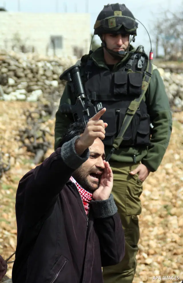 Protesters argue with an Israeli soldier during a demonstration against Israel's controversial separation barrier in the West Bank village of Maasarah, near the biblical town of Bethlehem on March 25, 2011.Israel says th...