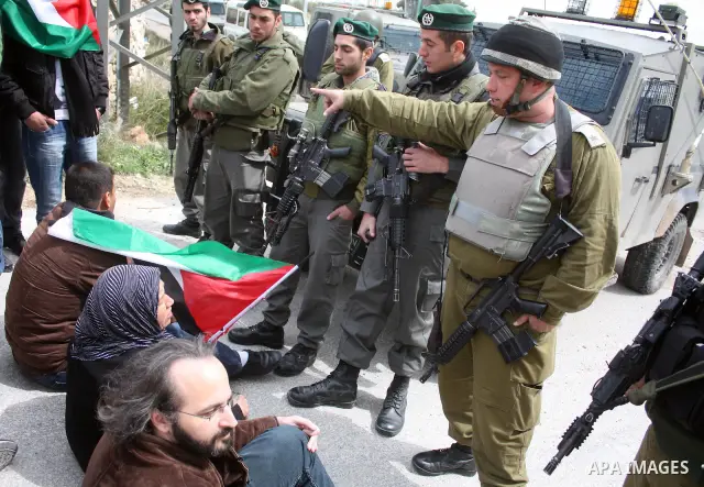 Protesters argue with an Israeli soldier during a demonstration against Israel's controversial separation barrier in the West Bank village of Maasarah, near the biblical town of Bethlehem on March 25, 2011.Israel says th...