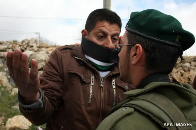 Protesters argue with an Israeli soldier during a demonstration against Israel's controversial separation barrier in the West Bank village of Maasarah, near the biblical town of Bethlehem on March 25, 2011.Israel says th...