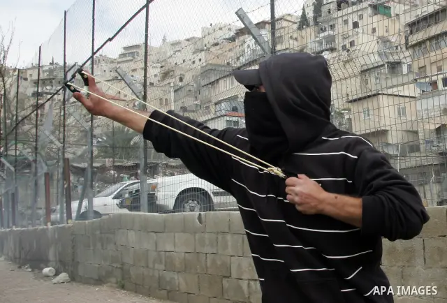 Palestinian youths hurl stones towards Israeli border police during clashes in the mostly Arab neighborhood of Silwan in East Jerusalem March 25, 2011. Photo by Mahfouz Abu Turk .