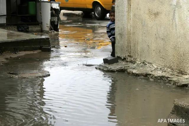 Palestinian boy looks at a pool of rain water in the Rafah refugee camp southern Gaza Strip on March 25, 2011.Photo Abed Rahim Khatib