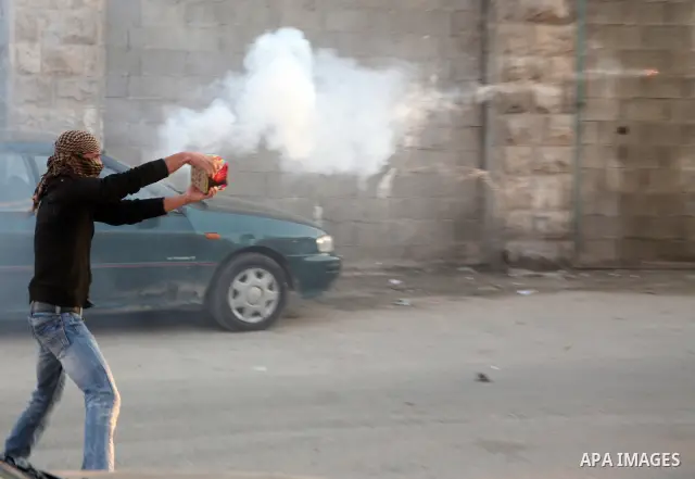 A Palestinian youth launches fireworks towards Israeli soldiers during clashes in the Shuafat Refugee Camp, north of Jerusalem 26 March 2011. Photo by Sliman Khader