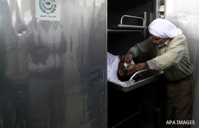 A Palestinian man cleans the body of one of the tow killed Palestinians, at the morgue in Kamal Adwan hospital in the town of Beit Lahiya, northern Gaza Strip, on March27 2011.