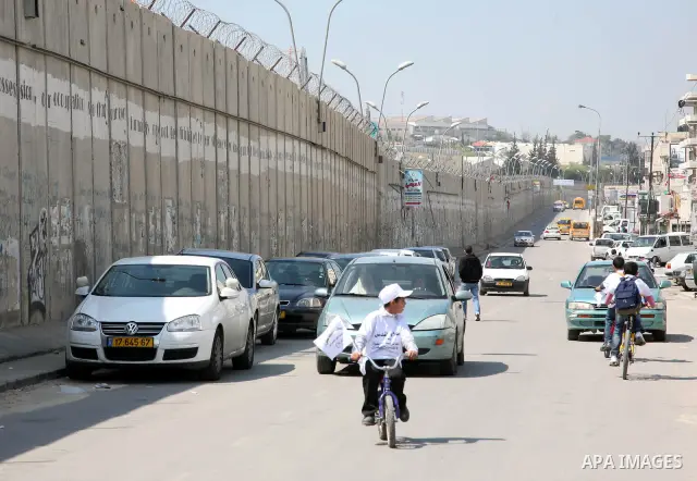 Palestinian children ride their bikes near the Israeli separation barrier during a festival under the title 'yes to life, yes to sports, no drug', in Al-Ram in the West Bank with the participation of the Directorate of E...
