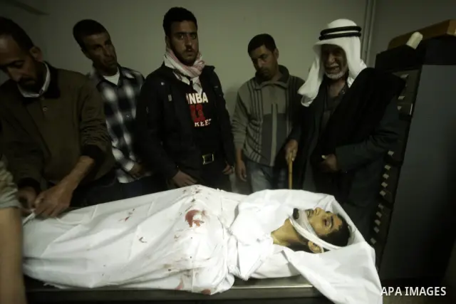 Palestinian relatives mourn over the body of Mohammed Muammar, who was killed during an Israeli air strike the previous day, in Khan Yunis, southern Gaza Strip, on March 30, 2011. The raid killed Muammar and wounded the...