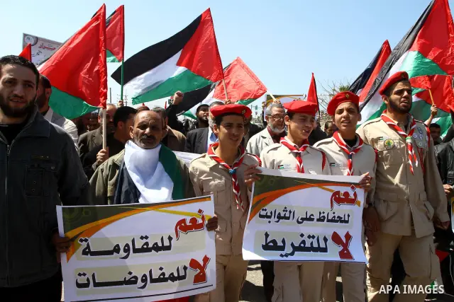 Palestinians wave their national flag and hold pictures of Palestinian prisoners jailed in Israel during a sit-in in Beit Hanun, northern Gaza Strip, on March 30, 2011 as hundreds of people across Israel and Palestinian...