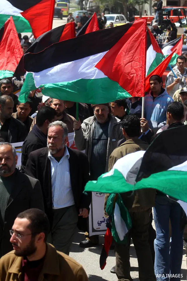 Palestinians wave their national flag and hold pictures of Palestinian prisoners jailed in Israel during a sit-in in Beit Hanun, northern Gaza Strip, on March 30, 2011 as hundreds of people across Israel and Palestinian...