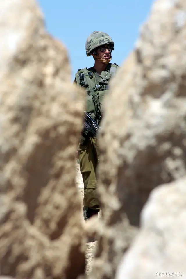 Israeli soldier stands guard as Palestinian prime minister Salam Fayyad visits in the southern town of Yatta, near Hebron in the occupied West Bank, on March 30, 2011, as hundreds of people across Israel and Palestinian...