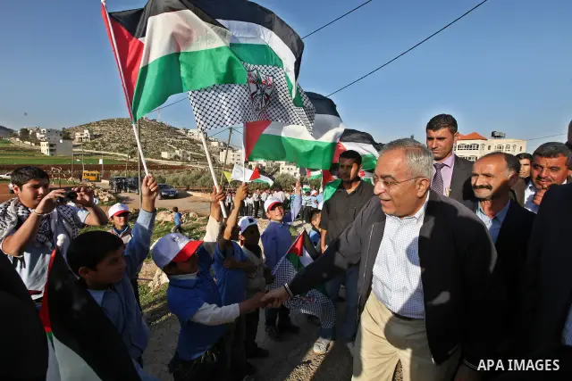 Palestinian prime minister Salam Fayyad plants olive trees in al-Magher village near Ramallah in the occupied West Bank, on March 30, 2011, as hundreds of people across Israel and Palestinian territories were holding a s...