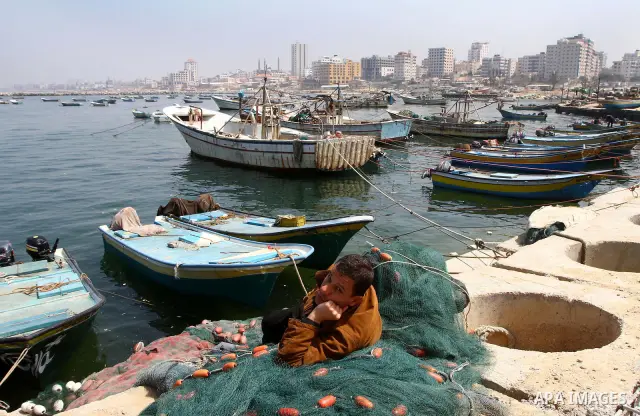 Palestinian fisherman fixes his fishing nets at the port in Gaza City 30, 2011. Israel is considering building an artificial island with sea and air ports off blockaded Gaza, as a long-term solution to shipping goods int...