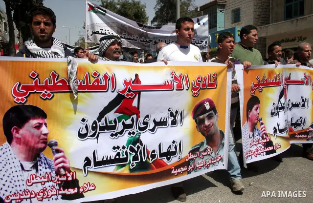 Palestinian protesters take part in a march in solidarity with Palestinian prisoners in Israeli jails and calling for end the split between the two rival leading Palestinian factions Fatah and Hamas, in the West Bank cit...