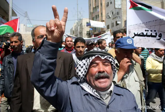 Palestinian protesters take part in a march in solidarity with Palestinian prisoners in Israeli jails and calling for end the split between the two rival leading Palestinian factions Fatah and Hamas, in the West Bank cit...