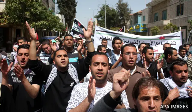 Palestinian protesters take part in a march in solidarity with Palestinian prisoners in Israeli jails and calling for end the split between the two rival leading Palestinian factions Fatah and Hamas, in the West Bank cit...