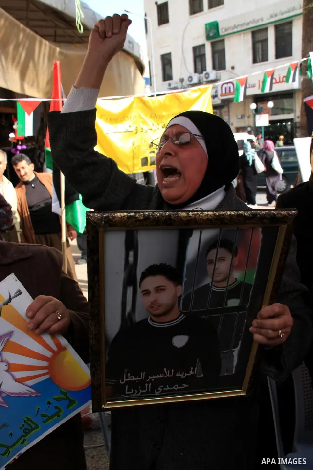 Palestinians man holds portraits of relatives, during a protest calling for the release of Palestinian prisoners from Israeli jails, in the West Bank city of Nablus , Thursday, March 31, 2011. Israel currently holds abou...