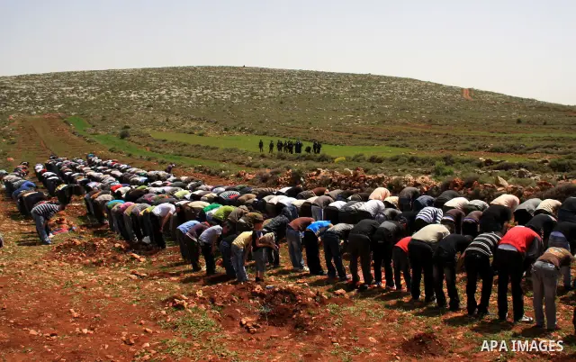 Israeli soldiers keep watch as Palestinians perform Friday prayers on an open field in the village of Qusra, near the Jewish settlement of Shilo, in the Israeli-occupied West Bank, on April 1, 2011. Photo by Wagdi Eshtay...