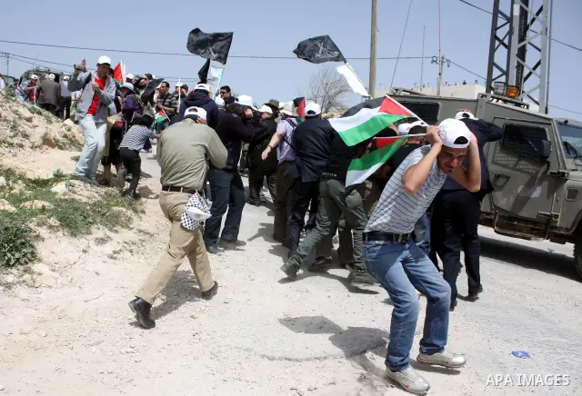 Israeli soldiers fire tear gas canisters towards demonstrators during a protest against Israel's controversial separation barrier and to mark "Land Day" in the West Bank village of Maasarah, near the biblical town of Bet...