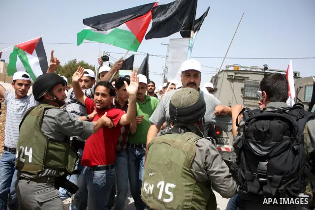 Israeli soldiers scuffle with demonstrators during a protest against Israel's controversial separation barrier and to mark "Land Day" in the West Bank village of Maasarah, near the biblical town of Bethlehem, on April 01...