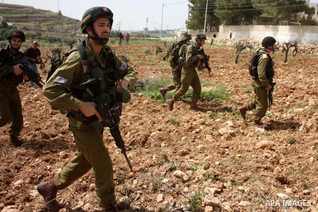 Israeli soldiers scuffle with demonstrators during a protest against Israel's controversial separation barrier and to mark "Land Day" in the West Bank village of Maasarah, near the biblical town of Bethlehem, on April 01...