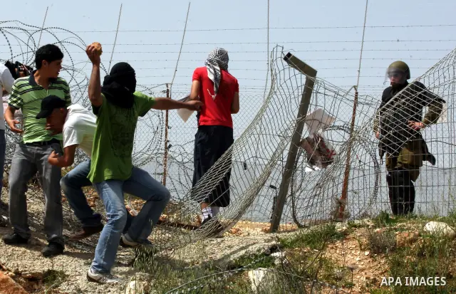 Palestinian demonstrators hurl stones towards Israeli forces during clashes following a weekly demonstration against Israel's separation barrier in the Palestinian West Bank village of Bilin on April 01, 2011. Photo by I...