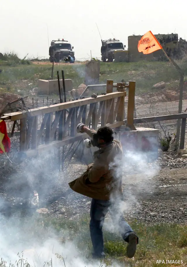 Palestinian demonstrators hurl stones towards Israeli forces during clashes following a weekly demonstration against Israel's separation barrier in the Palestinian West Bank village of Bilin on April 01, 2011. Photo by I...