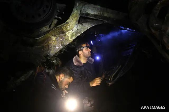 Members of Hamas' security forces inspect a car after an Israeli air strike in Deir Al-Balah in the central Gaza Strip early April 2, 2011. Israeli aircraft killed three Palestinian gunmen in the southern Gaza Strip earl...